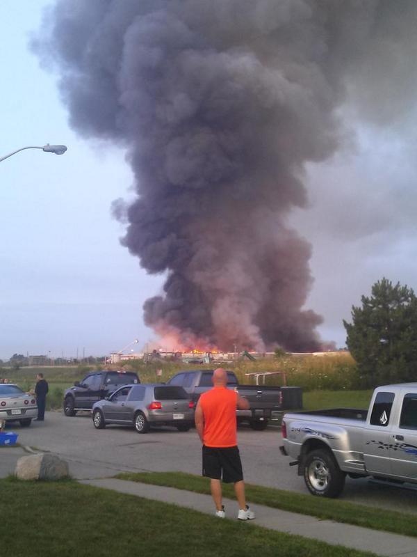 Large plumes of black smoke continue to pour out of the Bonduelle plant in Tecumseh, Ont., as fire crews continue to the battle the blaze on Friday, July 18, 2014. (Arms Bumanlag/ AM800)