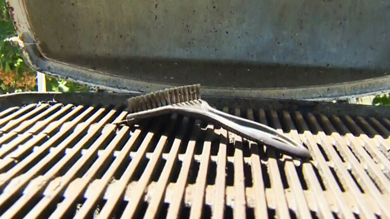 A barbecue cleaning brush sits on a grill