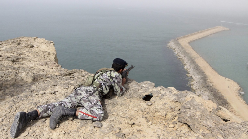 A member of the Iranian military takes position in a drill on the shore of the sea of Oman, on Friday, Dec. 30, 2011. (AP Photo/YJC, Mohammad Ali Marizad)
