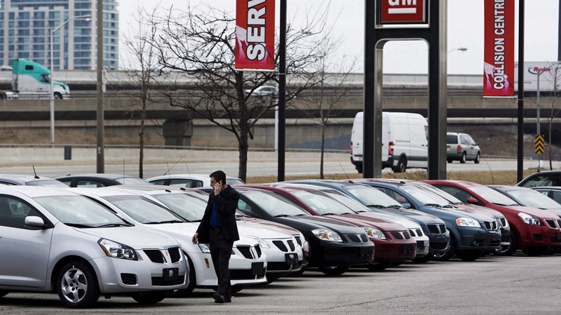 A man walks past cars at a General Motors dealership in Toronto on Thursday, March 5, 2009. THE CANADIAN PRESS/Nathan Denette
