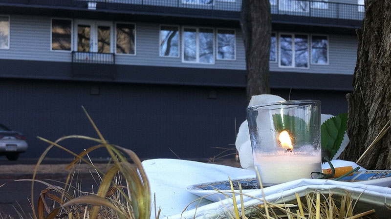 A candle flickers in memory of a woman found dead in an apartment complex on Jasper Ave. and 83 St. on New Year's Eve. Tuesday, January 3.