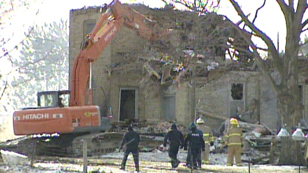 Heavy equipment is used to knock down walls following a house fire in Blandford-Blenheim Township, Ont. on Tuesday, Jan. 3, 2012.