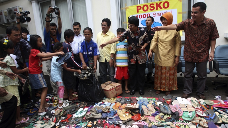 Indonesian children bring pairs of sandals at the office of Indonesian Commission for Child Protection in Jakarta, Indonesia, Tuesday, Jan. 3, 2012, to help protest for a 15-year-old boy who is being prosecuted for lifting an old pair of sandals 