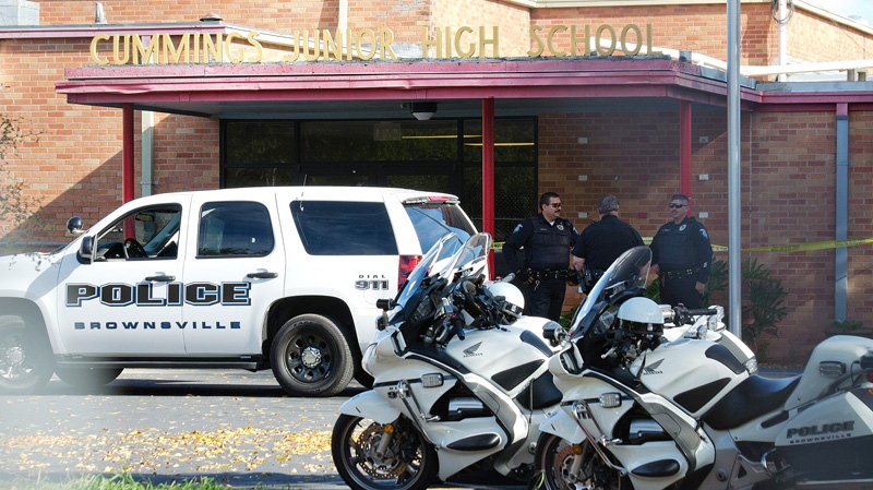 Brownsville police officers stand in front of Cummings Middle School in Brownsville, Texas after police shot and killed an armed eighth-grader who brandished a weapon in the main hallway of his middle school on Wednesday, Jan. 4, 2012. (AP / The Brownsville Herald, Paul Chouy)