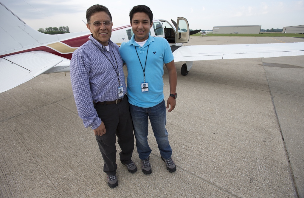 Babar and Haris Suleman stand next to plane 