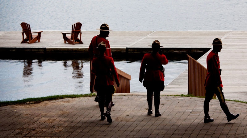 Four RCMP officers walk the shore of Peninsula Lake as final preparations are made for the arrival of the leaders to the Muskoka 2010 G8 summit at the Deerhurst Resort in Huntsville, Ont., on June 24, 2010. (Sean Kilpatrick / THE CANADIAN PRESS)