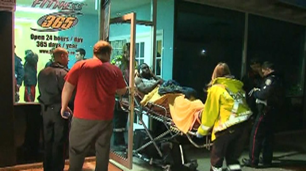 A man is wheeled out of a fitness centre following a shooting that injured three people late Sunday, Jan. 8, 2012.