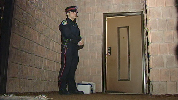 A Waterloo Regional Police Service officer stands outside the Green Valley Drive apartment of Larry McDonald in Kitchener, Ont. in March 2010.