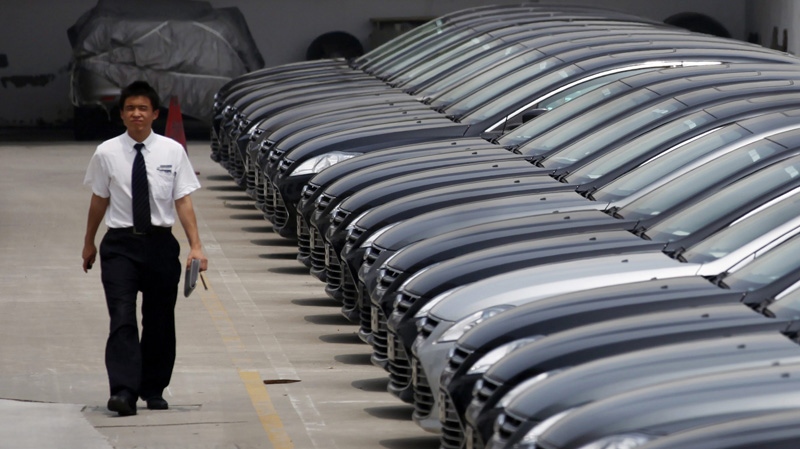 A man walks past brand new cars at a car dealer in Shanghai, China, Wednesday June 8, 2011. (AP Photo/Eugene Hoshiko)