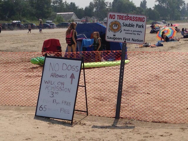 Signs on a portion of the shoreline of Sauble Beach, Ont. controlled by the Saugeen First Nation is seen on Friday, Aug. 1, 2014. (Scott Miller / CTV London)