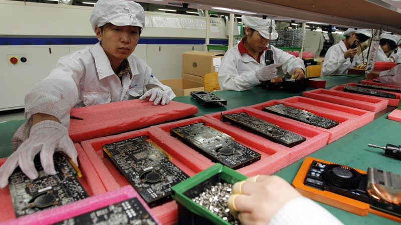 In this May 26, 2010 file photo, staff members work on the production line at the Foxconn complex in the southern Chinese city of Shenzhen.  (AP Photo/Kin Cheung, File)