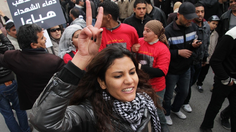 A Tunisian woman makes a peace sign during a gathering at Habib Bourguiba avenue in Tunis to celebrate the one year anniversary of the revolution, Saturday, Jan. 14, 2012.