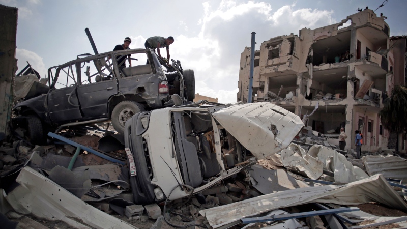 Palestinians search destroyed cars in Rafah's district of Shawkah in the southern Gaza Strip, Tuesday, Aug. 5, 2014. (AP / Khalil Hamra)