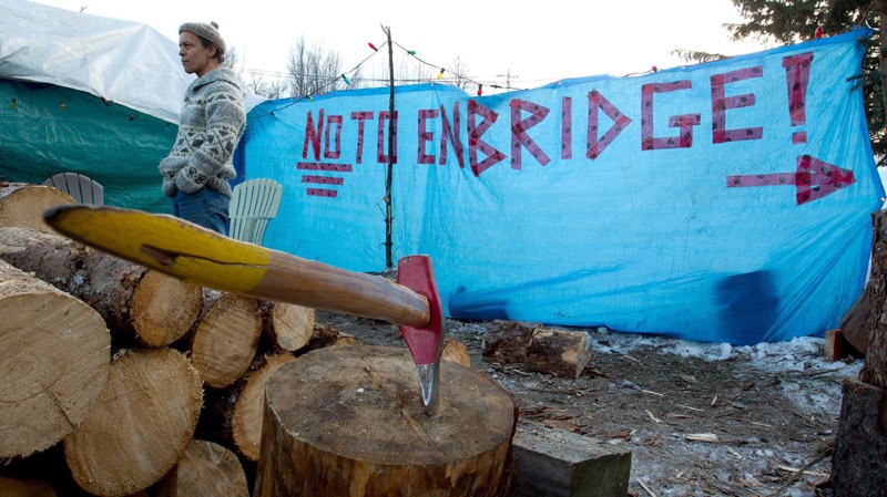 Charles Heit, a Gitxsan First Nation member opposed to the $5.5-billion Enbridge oil pipeline from Alberta to the British Columbia port of Kitimat warms himself beside a fire at a camp outside the Gitxsan Treaty Office in Hazelton, B.C., on Thursday January 12, 2012. 