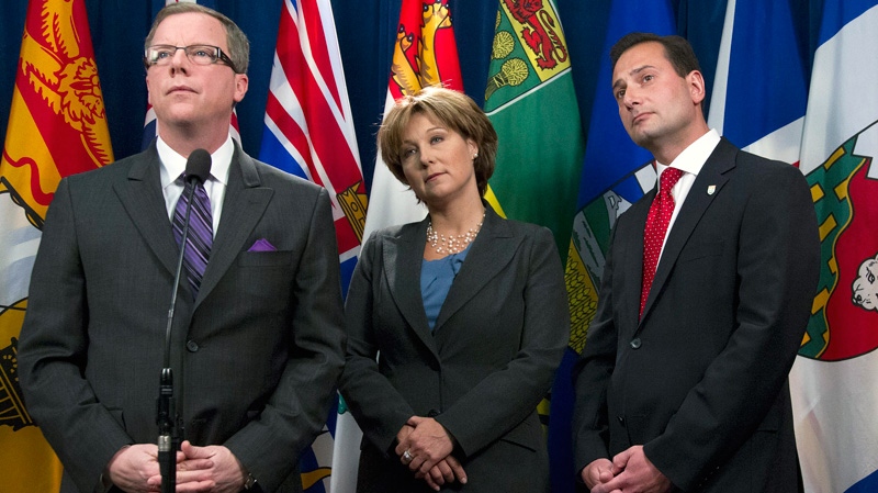Saskatchewan Premier Brad Wall, left, talks to media while fellow premiers Christy Clark of British Columbia and Robert Ghiz of Prince Edward Island look on during a break in the meeting of The Council of the Federation in Victoria, B.C. Tuesday, Jan. 17, 2012. (Jonathan Hayward / THE CANADIAN PRESS)