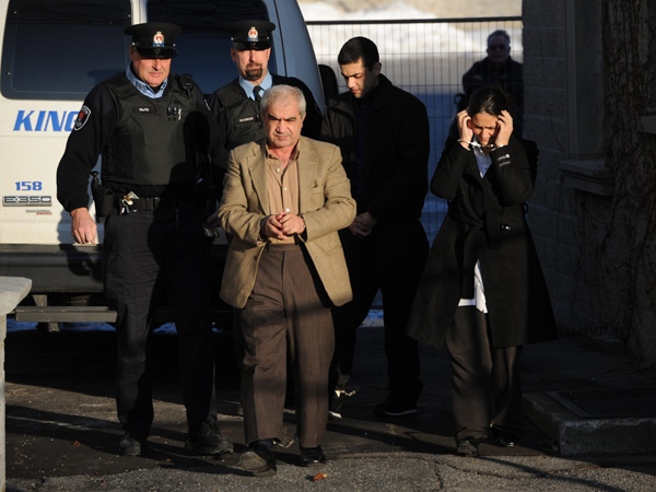 Tooba Mohammad Yahya and husband Mohammad Shafia and their son Hamed Mohammed Shafia are escorted by police officers into the Frontenac County courthouse in Kingston, Ontario on Wednesday, Jan. 18, 2012. (Sean Kilpatrick / THE CANADIAN PRESS)