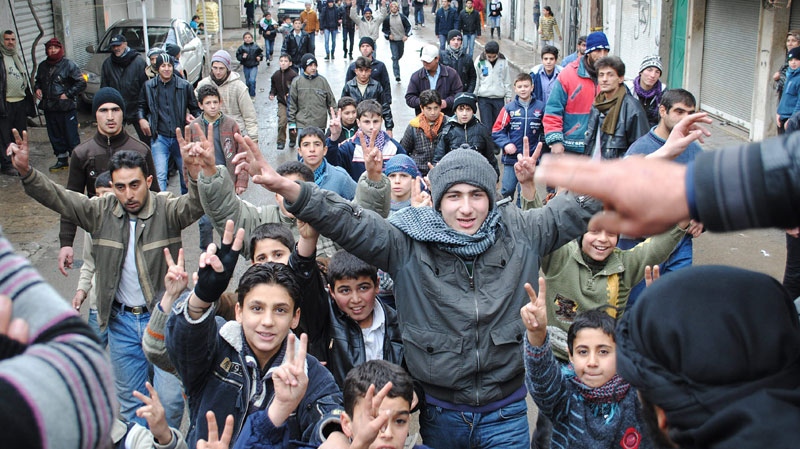 In this Tuesday, Jan. 17, 2012 photo, anti-Syrian regime protesters chant slogans and flash the victory sign as they march during a demonstration at the mountain resort town of Zabadani, Syria, near the Lebanese border.