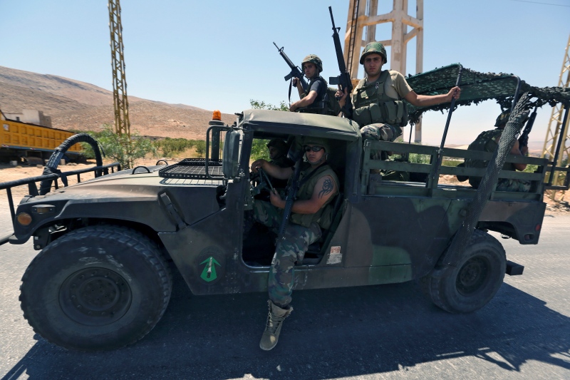 Lebanese army soldiers sit on top of a military truck as reinforcements arrive to the outskirts of Arsal, a predominantly Sunni Muslim town near the Syrian border in eastern Lebanon, Monday, Aug. 4, 2014. (AP Photo/Bilal Hussein)