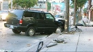 A smashed SUV sits at the scene of a collision with a pedestrian on Queen Street East in Toronto, Monday, Aug. 18, 2014. 