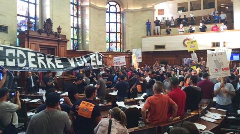 Protesters are seen inside council chambers Monday