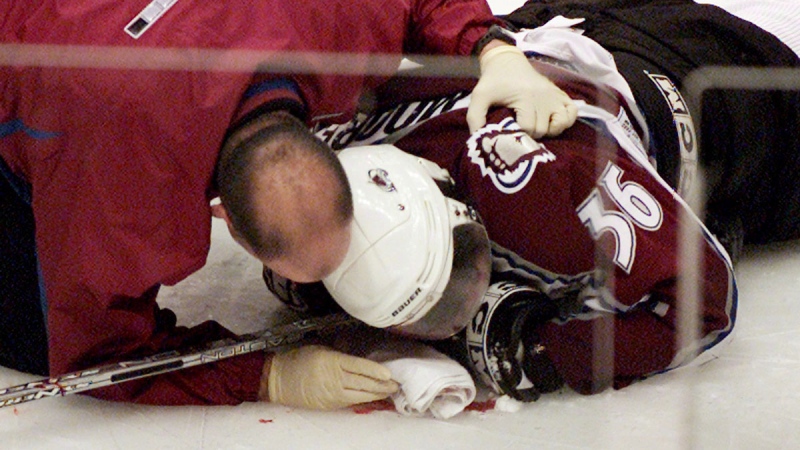 Colorado Avalanche forward Steve Moore is attended to by the team trainer after being hit by Vancouver Canucks Todd Bertuzzi in Vancouver, B.C., on March 8, 2004. (THE CANADIAN PRESS / Chuck Stoody)