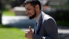 Khurram Syed Sher gives a thumbs up outside court in Ottawa on Tuesday, Aug. 19, 2014. (Sean Kilpatrick / THE CANADIAN PRESS)