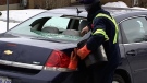 A woman cleans off her car after it was broken into while parked in the garage of her west Ottawa condominium Tuesday, Jan. 24, 2012. 