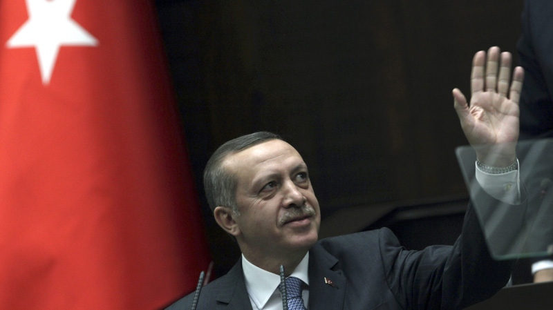 Turkish Prime Minister Recep Tayyip Erdogan salutes lawmakers and supporters of his party as he addresses at the parliament in Ankara, Turkey, Tuesday, Jan. 24, 2012. (AP Photo/Burhan Ozbilici)