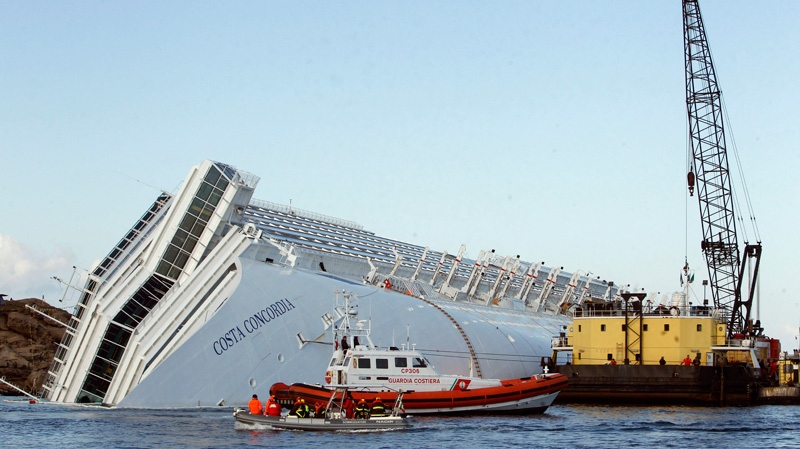 A sea platform carrying a crane approaches the grounded cruise ship Costa Concordia off the Tuscan island of Giglio, Italy, Tuesday, Jan. 24, 2012. (AP / Pier Paolo Cito)