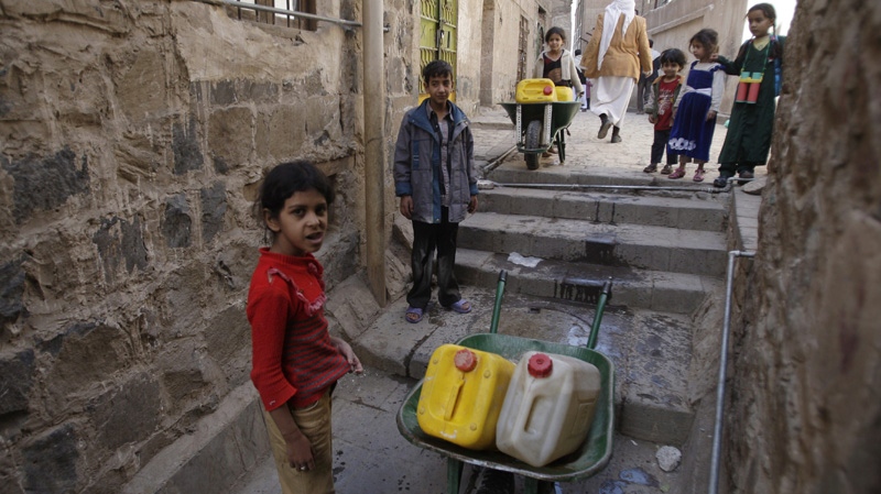 Yemeni children gather as they collect water in an alley of the old city of Sanaa, Yemen, Wednesday, Dec. 14, 2011. (AP Photo/Hani Mohammed)