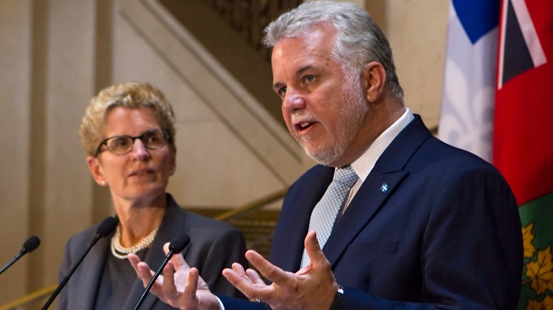 Quebec Premier Philippe Couillard, right, gestures