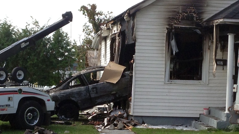 A tow truck pulls a Pontiac Sunfire out of a home in Oshawa on Friday, Aug. 22, 2014. (Jeff Long / CTV Toronto)
