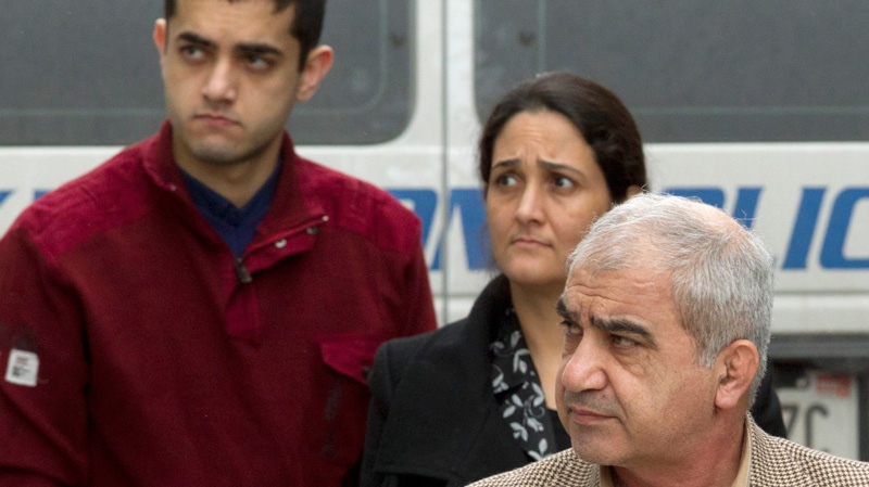 Mohammad Shafia, right, Tooba Yahya, centre, and their son Hamed Mohammed Shafia, left, are escorted into the Frontenac County courthouse in Kingston, Ont., Thursday, Jan. 26, 2012. 9Frank Gunn / THE CANADIAN PRESS)