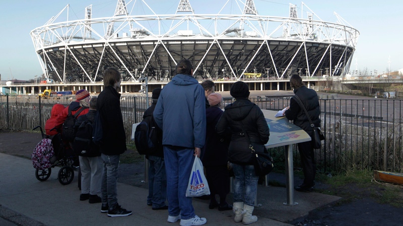 People look at the main Olympic Stadium by the Olympic Park in London, Friday, Jan. 27, 2012.