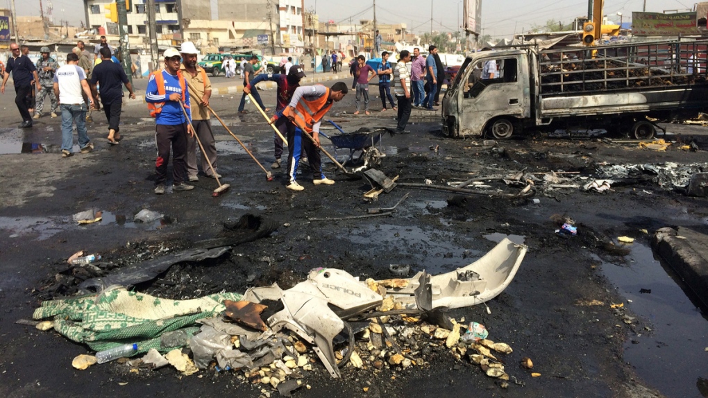 Workers clean up car bomb site in Iraq
