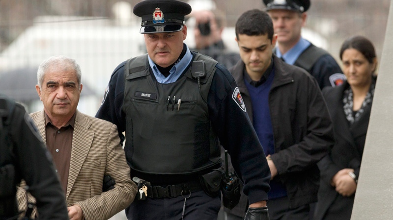 Mohammad Shafia, front, Tooba Yahya, back, and their son Hamed Shafia, middle, are escorted into the Frontenac County courthouse in Kingston, Ont., Friday, Jan. 27, 2012. (Frank Gunn / THE CANADIAN PRESS)