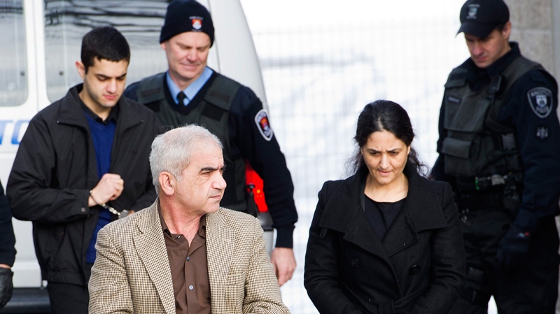 Mohammad Shafia, front left, Tooba Yahya, front right, and their son Hamed Shafia, back left, are escorted at the Frontenac County courthouse in Kingston, Ontario on Saturday, January 28, 2012.