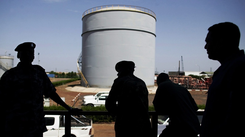In this Wednesday, Nov. 17, 2010 file photo, Southern Sudanese security forces wait outside the control room of the Petrodar oil facility in Paloich, South Sudan.