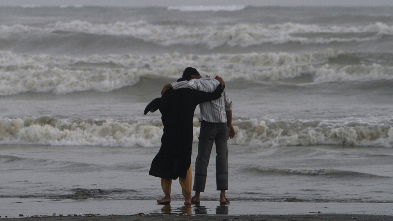 In this May 25, 2010 file photo, a Pakistani couple walk by the sea on Clinfton beach in Karachi, Pakistan. (AP Photo/Shakil Adil, File)