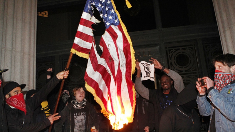 Occupy Oakland protestors burn an American flag found inside Oakland City Hall during an Occupy Oakland protest on the steps of City Hall, Saturday, January 28, 2012, in Oakland, Calif. (AP Photo/Beck Diefenbach)