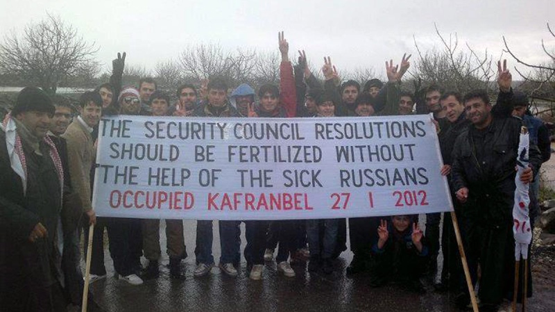 In this citizen journalism image provide by the Local Coordination Committees in Syria, anti-Syrian regime protesters, hold a banner against Russia during a demonstration, at Kfar-Nebel town in Edleb province, Syria, on Friday Jan. 27, 2012. 