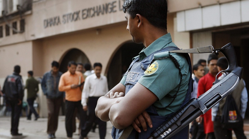 A Bangladeshi riot policeman stands guard in front of the Dhaka Stock Exchange during a demonstration by investors against the sharp fall in share prices in Dhaka, Bangladesh, Tuesday, Jan. 24, 2012. (AP Photo/ Pavel Rahman)