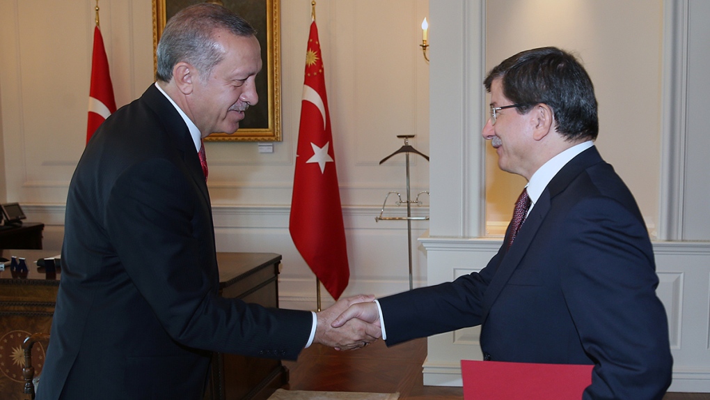 Turkey's new PM shakes hands with Erdogan