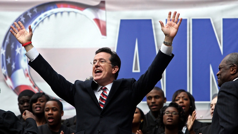 Comedian and Charleston native Stephen Colbert, left, sings to the crowd during the "Rock Me Like a Herman Cain South Cain-olina Primary Rally" at the College of Charleston in Charleston, S.C., on Friday, Jan. 20, 2012. (AP Photo/The Post And Courier, Grace Beahm)