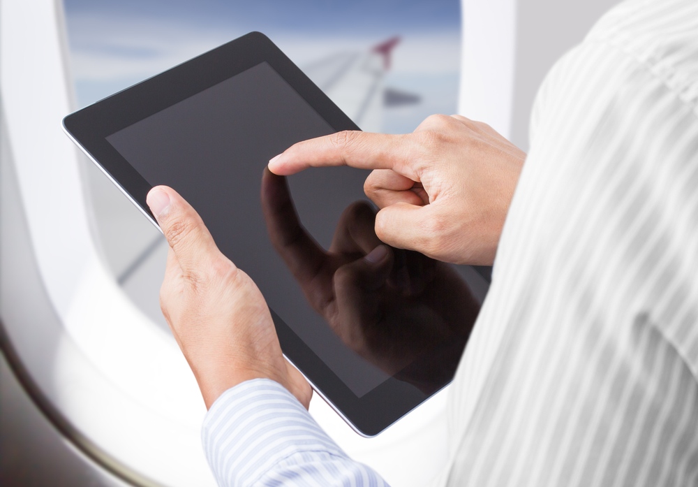 Man uses tablet on plane