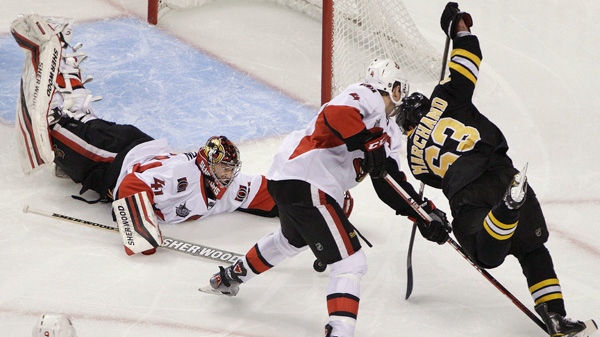 Ottawa Senators goalie Craig Anderson (41) dives but he and defenseman Chris Phillips (4) cannot stop a shot for a goal by Boston Bruins left wing Brad Marchand (63) in the third period of an NHL hockey game in Boston, Tuesday, Jan. 31, 2012. (AP Photo/Elise Amendola)