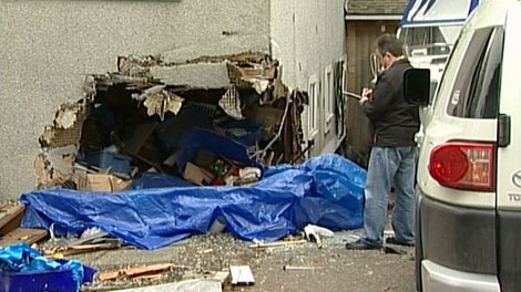A contractor surveys the damage caused when a Jaguar slammed into a Saanich home. Feb. 2, 2012. (CTV)