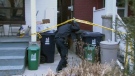 A police officer moves towards the crime scene behind Clendenan Ave. on Thursday, Feb. 2, 2012.