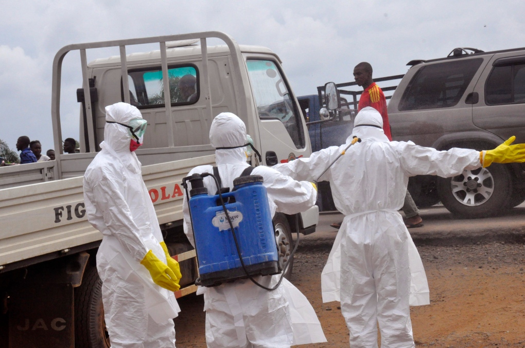 Health workers spray each other in Monrovia