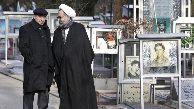 Iranian Intelligence Minister Heidar Moslehi, right, talks to Interior Minister Mohammad Mostafa Najjar, while cabinet members visit and pay respect at the graves of Iranian soldiers who were killed during the 1980's Iran-Iraq war, in a ceremony commemorating 33rd anniversary of Iran's 1979 Islamic Revolution, at the Behesht-e-Zahra cemetery, just outside Tehran, Iran, Saturday, Feb. 4, 2012. (AP Photo/Vahid Salemi)